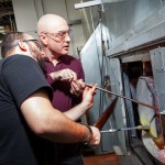 Chris Giordano assists a local Veteran in gathering glass from the furnace