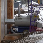 Propane heaters add warm air to the lower level of the construction area.