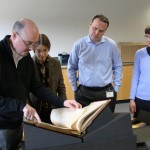 Galbraith and staff members examine a rare book.