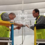 Museum staff putting together Evening by Cerith Wyn Evans, a colorless double-tiered glass chandelier.