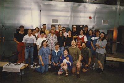 Amy, Bill, and their young daughter pose for a group picture with an early class at The Studio.