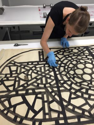 Bonnie removes dirt that has lightly accumulated overall on a paper cartoon for Temple Emanu-El, New York City, BIB#148145