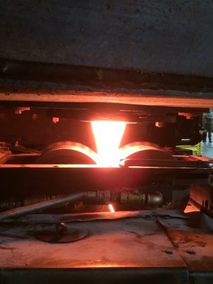 Molten glass sags through an opening to form a ribbon of glass.