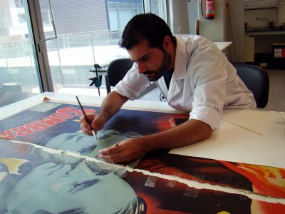 Photograph of Pascual conserving a poster