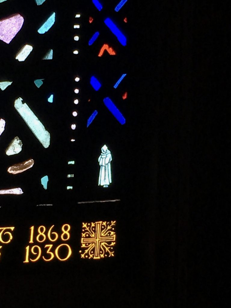 A white friar in the bottom of one of the windows from the Church of the Heavenly Rest.