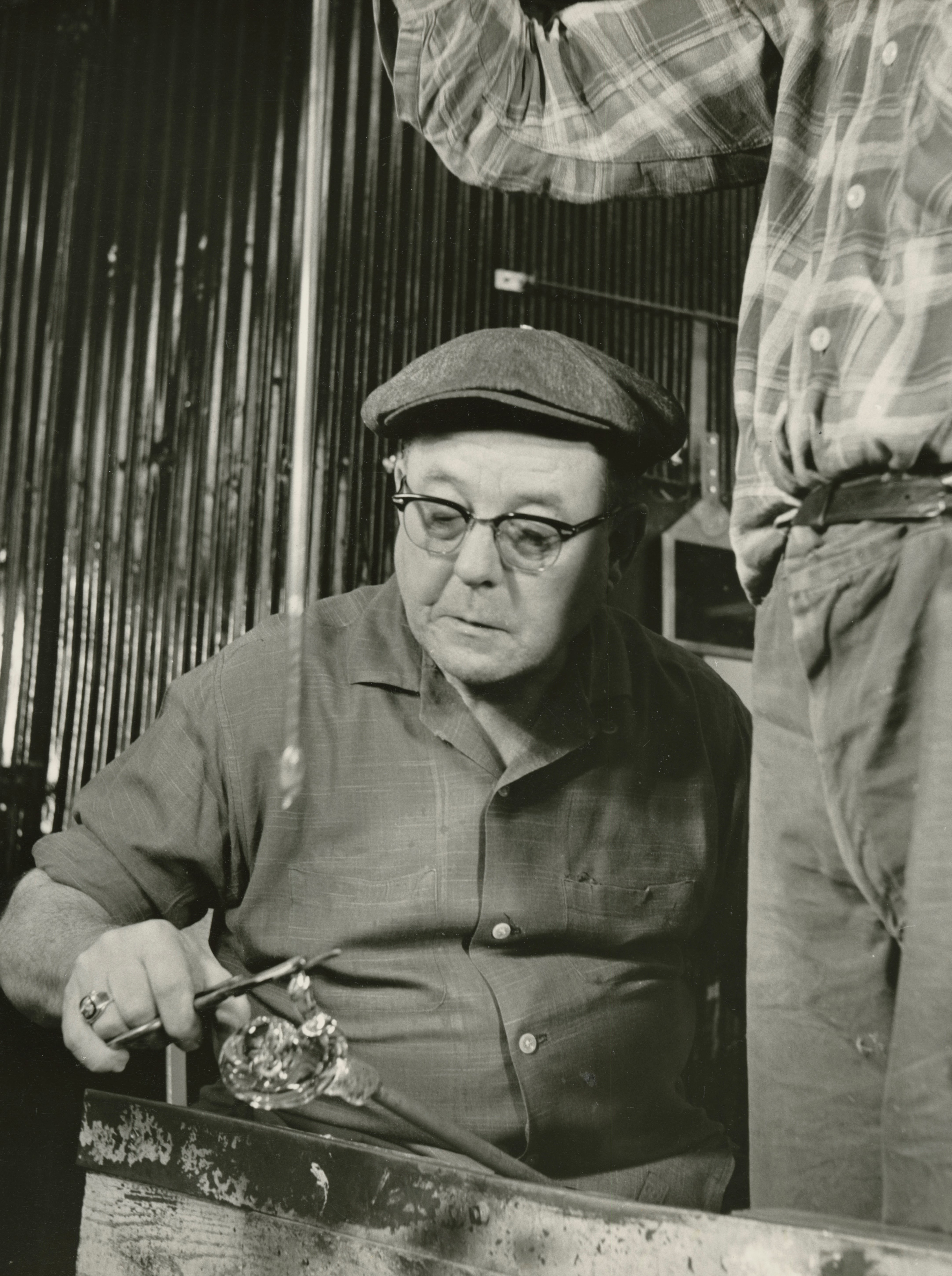 Photograph of a gaffer working on a piece of glass