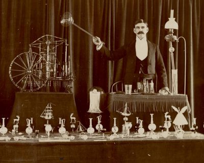 A glassworker, possibly F.A. Owen, and his steam-powered glass engine.