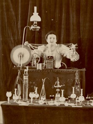 A glassworker, possibly Mrs. F.A. Owen, holds up spun glass.