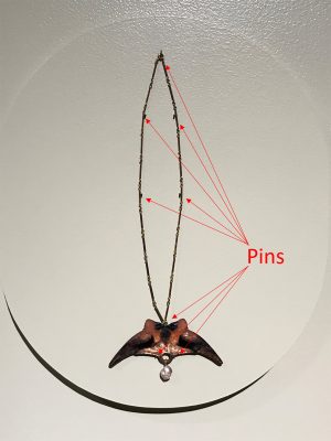 Though this necklace (90.3.37), displayed upright on a wall, appears to be floating, it is held in place with strategically placed pins.