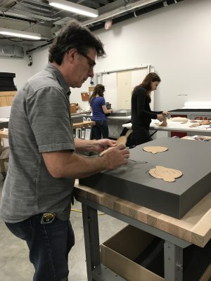 Tom Oberg, Preparator, makes a template by outlining each object.