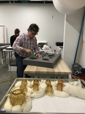 Tom cuts a void into the foam to fit each object.