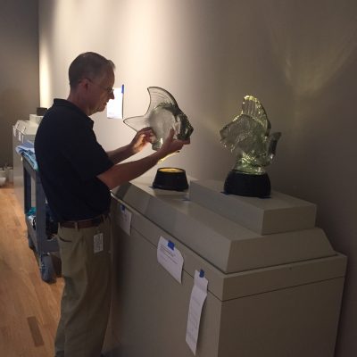 Steve carefully positioning the lamps in the open display case.